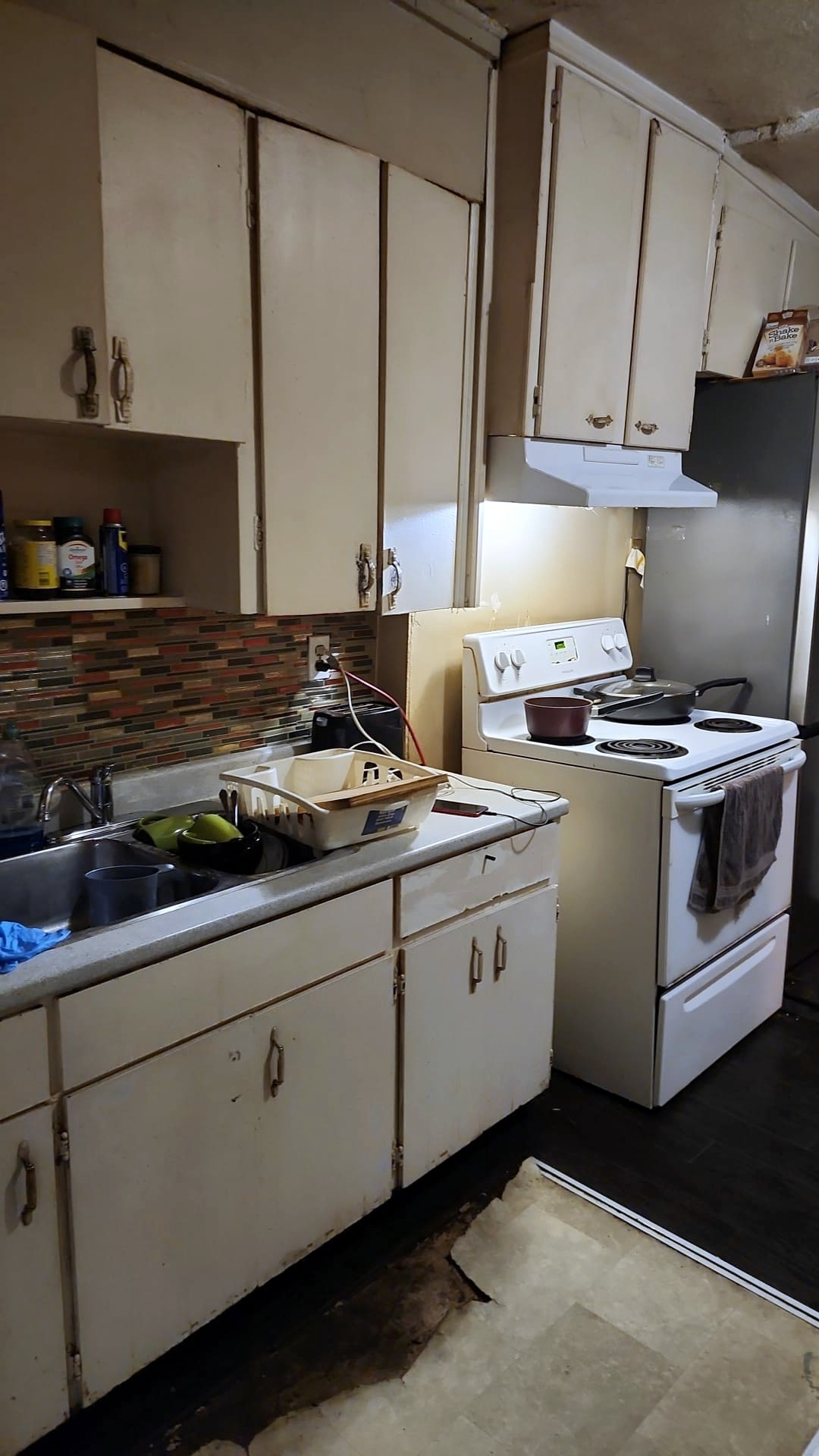 Cluttered kitchen counters and stove before cleaning