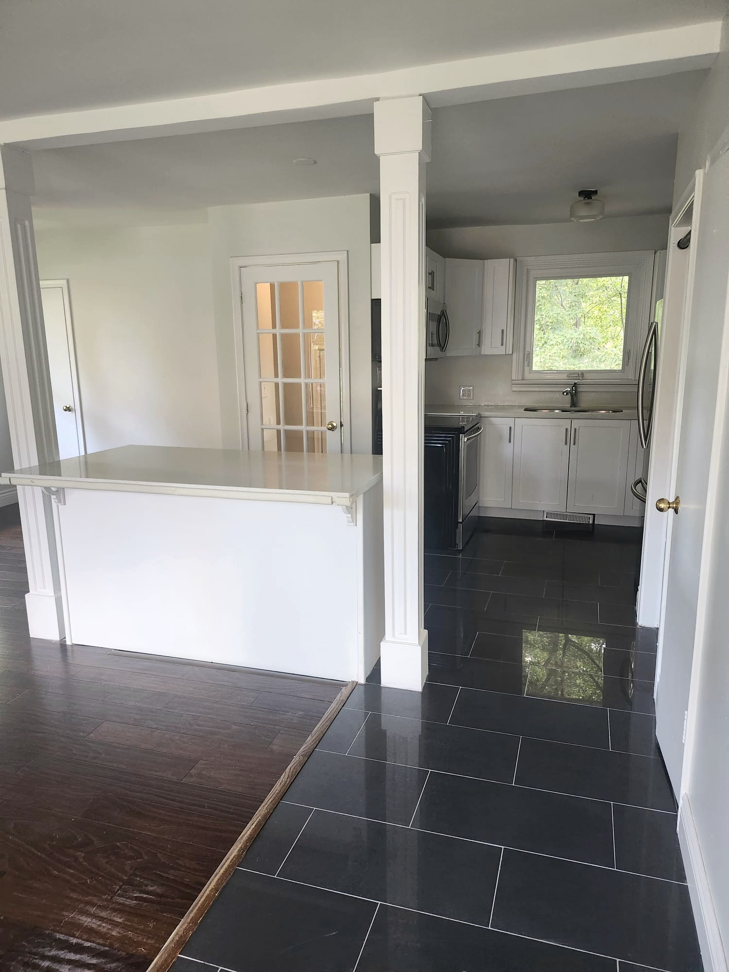 Empty kitchen with polished dark tile floors after a move-out clean