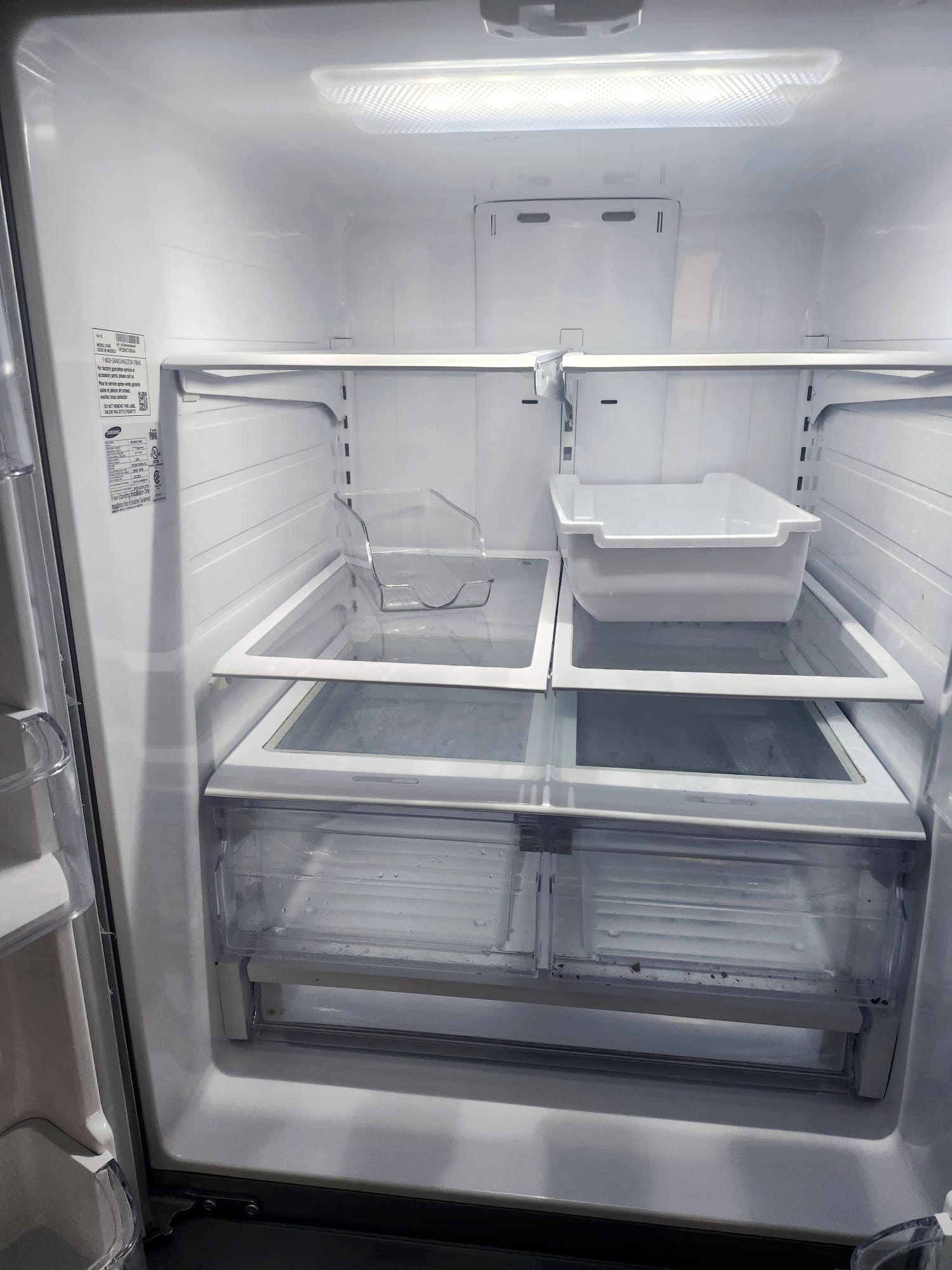 Empty fridge interior with shelves and drawers cleaned