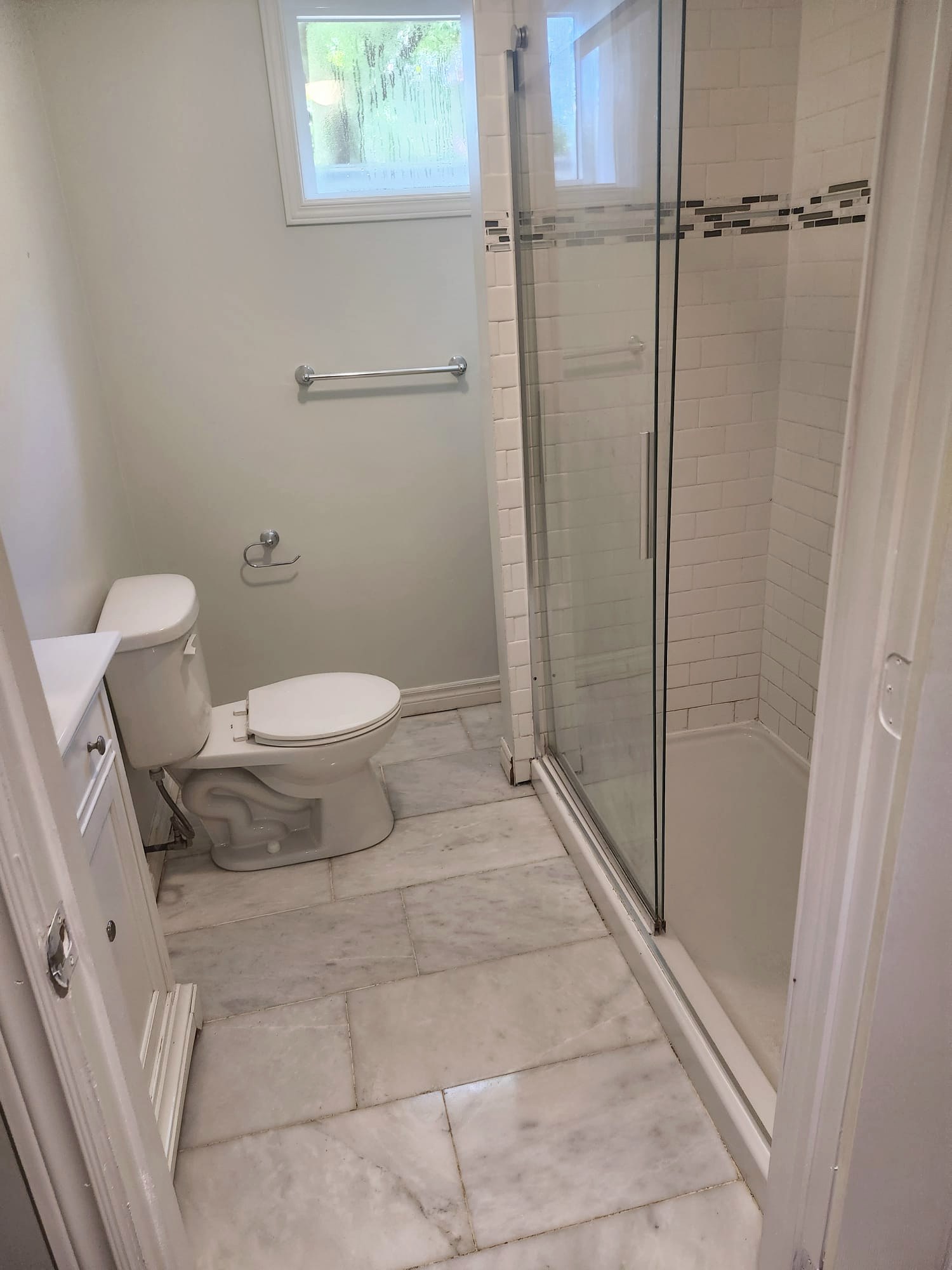 Clean bathroom with marble floor and glass shower after a move-out cleaning